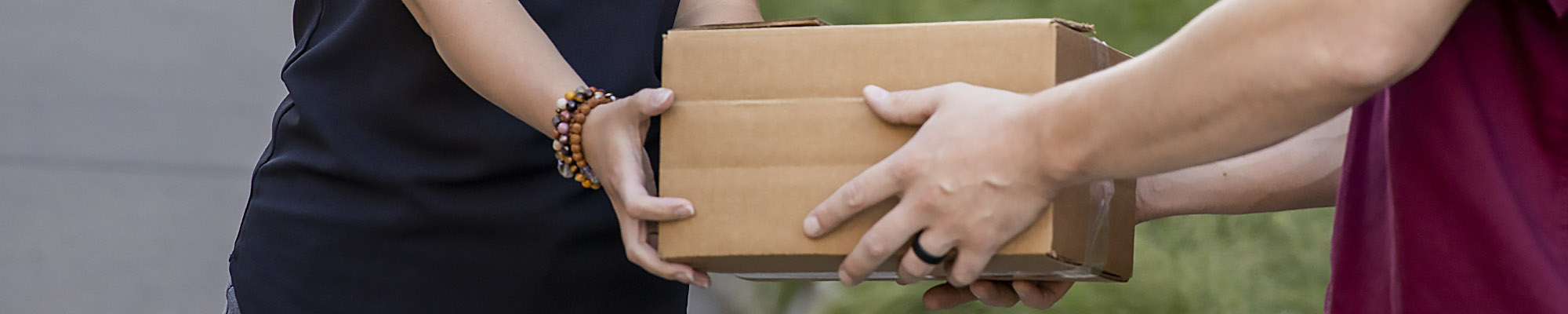 Close-up of a person handing off a package to someone else